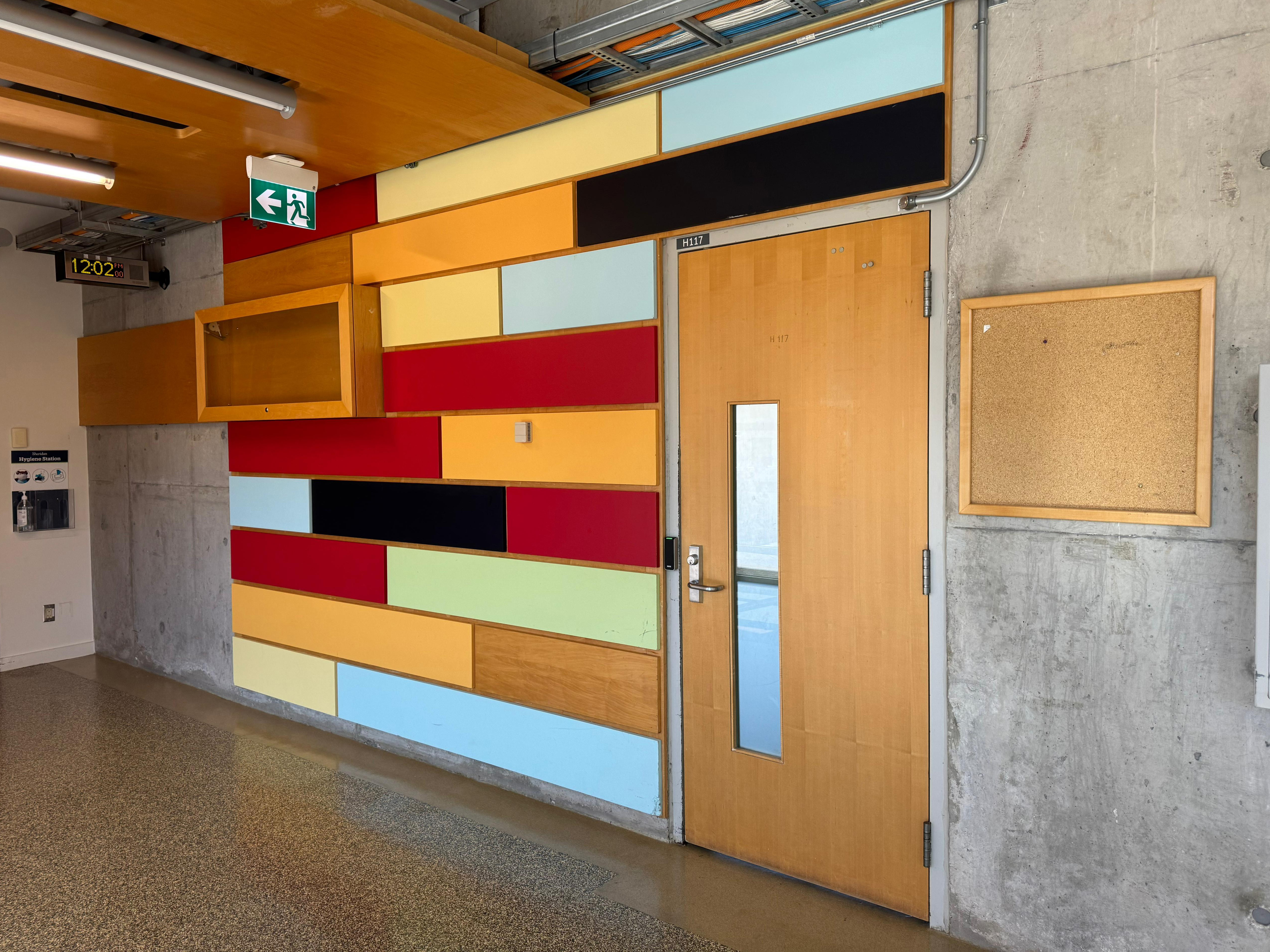 This picture is taken at H-Wing outside a classroom. Their primary use is for decoration, and for students to feel more energized with the splash of colour and unity showed on the wall. The building’s walls are built with concrete (brutalism), and having added materials like wood and paint, put together into a brick wall can bring a sense of stability and strength which inspires passersby.